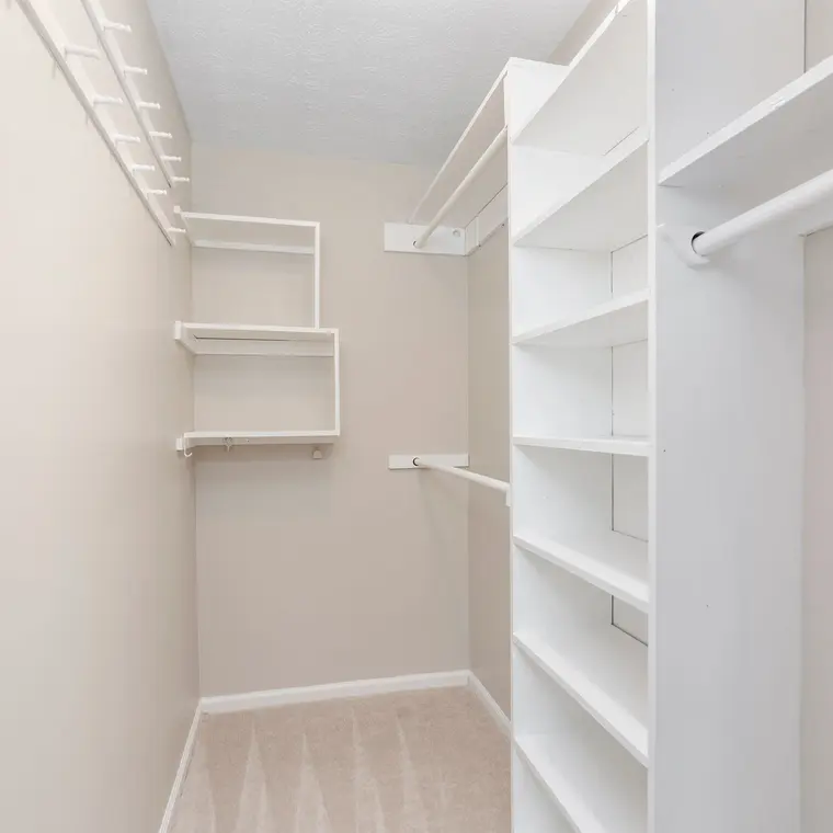 The same closet rebuilt with clean walls and new white shelving