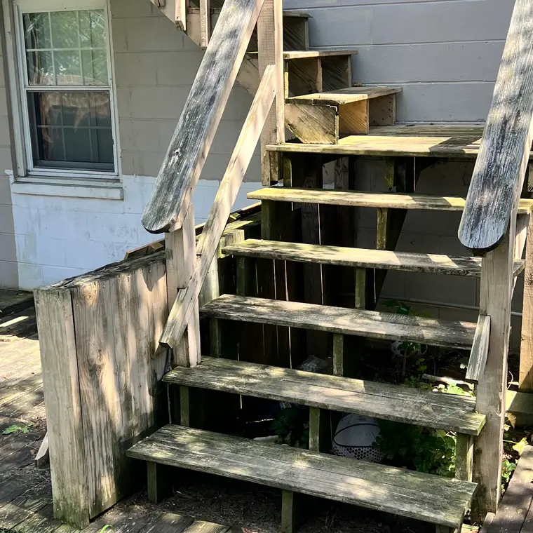 Rotted exterior deck stairs with weathered, broken treads